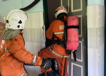 ANGGOTA bomba membantu menyelamatkan seorang wanita yang pengsan akibat sesak nafas dalam kebakaran bilik di tingkat atas sebuah rumah di Taman Bernam Baru, Tanjung Malim, Perak, hari ini. - IHSAN JBPM PERAK