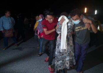 HURANI Awang, ibu kepada Allahyarham Asaari Leh terpaksa dipapah ahli keluarga selepas menyaksikan mayat anaknya itu tiba di Jeti Maritim Kelantan, Pasir Puteh malam tadi. - TOREK SULONG