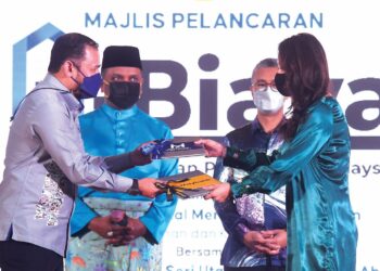 Pengerusi PR1MA, Datuk Dr. Fathul Bari Mat Jahya (kiri) dan Pengarah Eksekutif Maybank Venture, Sally Lye Saw Im bertukar dokumen kerjasama strategik antara PR1MA dan Maybank, sambil disaksikan Reezal Merican Naina Merican dan Tengku Zafrul Tengku Abdul Aziz pada Majlis Pelancaran i-Biaya di Sunway Resort Hotel, Petaling Jaya, semalam. – UTUSAN/SHIDDIEQIIN ZON