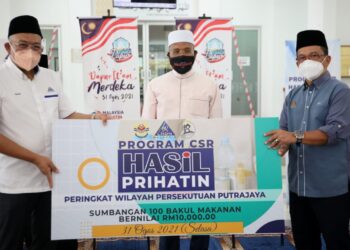 IDRIS Ahmad (tengah) menyaksikan penyampaian cek replika 100 bakul makanan sumbangan LHDN bernilai RM10,000 di bawah inisiatif Dapur It'am di Masjid Mahmoodiah, Presint 18, Putrajaya. - IHSAN JAWI