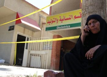 SEORANG wanita menghubungi ahli keluarganya di luar Hospital Yarmuk, di barat Baghdad. -AFP