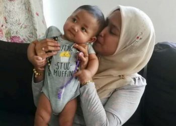 Nur Iwana Yazid tidak dapat menahan sebak sewaktu mendukung Adam Mikhael ketika ditemui di rumahnya di Kangar, semalam.