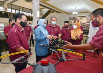 NORAINI Ahmad (tengah) mendengar taklimat berhubung program JAGADrone yang digunakan UTM untuk meningkatkan tahap keselamatan dalam kawasan kampus di Skudai, Johor.