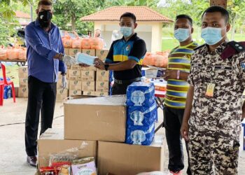 JASVIR Singh Ram Singh (kiri) mewakili Wan Rosdy Wan Ismail menyampaikan sumbangan pelitup muka dan keperluan makanan kepada petugas barisan hadapan di Kompleks Penjara Bentong, Pahang.