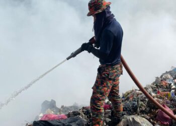 ANGGOTA bomba memadam kebakaran di tapak pelupusan sampah di Sungai Mekong, Jeli., Kelantan. - IHSAN BOMBA