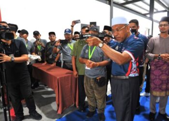 IDRIS Ahmad melakukan panahan sambil diperhatikan Pengerusi Jawatankuasa Hal Ehwal Agama Islam negeri, Mohd. Fared Mohd. Khalid (kanan) pada Majlis Penutup Mahrajan Memanah Recurve Sekolah Menengah Agama Peringkat Kebangsaan di Arena Emas, Taman Impian Emas, Johor Bahru, hari ini. - FOTO/RAJA JAAFAR ALI