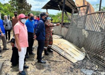 ONN Hafiz Ghazi (tengah) ketika melawat tempat kejadian yang mengakibatkan dua buah rumah terbakar di Kampung Gajah Mati, Mersing.