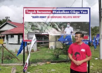 YEO Tung Siong berdiri berhampiran bahan kempennya yang telah dikoyakkan di Kampung Melayu Raya, Pekan Nanas di Pontian, Johor.