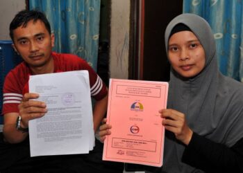 USMAN Abd. Razak (kiri) bersama Norhasyimah Muhamad Diah menunjukkan surat jual beli kediaman RIBJ di Taman Amar, Majidee ketika ditemui di rumah sewa mereka di Bandar Seri Alam, Masai, Pasir Gudang, Johor. - UTUSAN/RAJA JAAFAR ALI