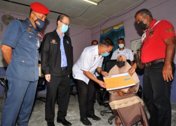 MAGLITA Varshay Ibrahim (duduk, dua kanan) dan suami, Ismadi Mustafa (kanan) menerima replika cek faedah Perkeso daripada Yahya Jaafar sambil disaksikan Tong Sing Chuang (dua kiri) di Flat Serantau, Larkin di Johor Bahru, Johor. -UTUSAN/RAJA JAAFAR ALI