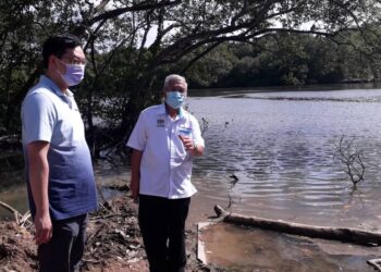 JIMMY Puah Wee Tse (kiri) bersama Hassan Abdul Karim meninjau keadaan Sungai Kim Kim, Pasir Gudang, Johor, semalam