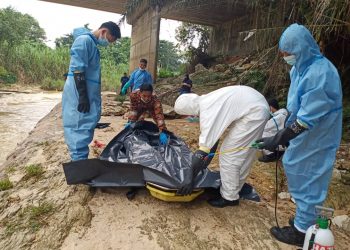 ANGGOTA bomba mengangkat mayat yang ditemukan di tebing sungai Linggi berhampiran jambatan di Taman Angsamas, Seremban petang tadi. - IHSAN BOMBA