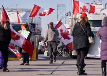 PESERTA protes anti-vaksin menghiasi trak dan kenderaan mereka dengan bendera Kanada semasa berhimpun di Jambatan Duta, Windsor.-AFP