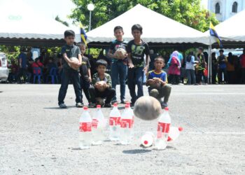 SEKUMPULAN kanak-kanak bermain ‘boling buah nyok’ dalam program sukan rakyat di Masjid Ibnu Taimiyyah, Tambun Tulang, Perlis, baru-baru ini. - MINGGUAN/IZLIZAN OTHMAN