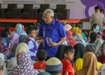 MAHDZIR Khalid menyampaikan sumbangan kepada salah seorang penerima pada Program CSR Pendidikan YPM Daerah Padang Terap di Pusat Komuniti Padang Kerasak, Padang Terap, Kedah. - FOTO/SHAHIR NOORDIN