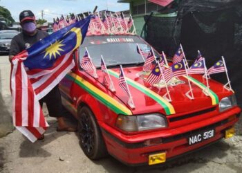 MOHAMAD Dahari Ani menunjukkan kereta Mazda miliknya yang dihias Jalur Gemilang di Semeling, Merbok, Kedah. - UTUSAN/ABD. RAZAK OSMAN