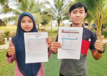 OMAR Mokhtar Abdul Rahman (kanan) dan Salmah Aminudin menunjukkan slip keputusan STPM mereka ketika ditemui di Pokok Sena, Kedah. - UTUSAN/MOHD RIFAAT ABD HAMID