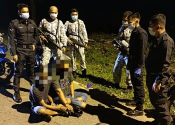 DUA suspek (duduk) yang ditahan oleh anggota  polis dan TLDM kerana dipercayai mengedar dadah di kawasan PKPD Bukit Malut di Langkawi, Kedah, Rabu lalu.