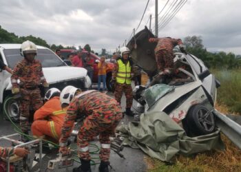 ANGGOTA bomba menjalankan operasi membawa keluar mangsa yang terlibat dalam nahas di Kilometer 15, Jalan Kampung Gajah-Tanjung Tualang dekat Kampung Gajah hari ini. - UTUSAN/JBPM PERAK