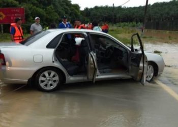 KERETA Proton Waja yang dinaiki Md. Rajihan Juaidi ditemui kira-kira 100 meter hari ini dari lokasi dia dilaporkan hanyut dibawa arus deras petang semalam. - IHSAN BOMBA