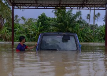 SEORANG penduduk melihat kenderaannya yang ditenggelami air.  Hujan berterusan semalam menyebabkan jumlah mangsa banjir di Terengganu meningkat. - UTUSAN/ PUQTRA HAIRRY ROSLI