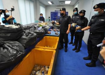 TOK Beng Yeow (empat dari kanan) menunjukkan bungkusan air ketum yang telah diproses dalam rampasan daun ketum seberat 380 kilogram pada sidang akhbar di IPD Kulai di Johor. - FOTO/RAJA JAAFAR ALI