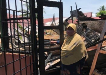 RAHANI Abdul Rashid menunjukkan rumahnya yang terbakar dipercayai akibat dipanah petir di Felda Chiku 2, Gua Musang, Kelantan, hari ini. - FOTO/AIMUNI TUAN LAH