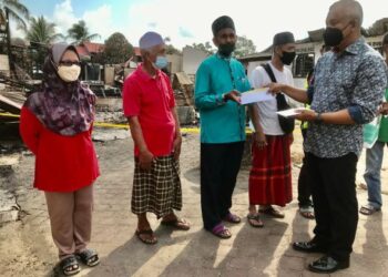 ABDUL Halim Shafai (kanan) menyampaikan bantuan wang hasil derma kilat kepada mangsa kebakaran di Kampung Dalam Rhu, Tumpat, Kelantan. hari ini. - FOTO/ROSLIZA MOHAMED