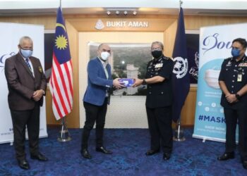 TENGKU Ezuan Ismara menyampaikan pelitup muka sumbangan Komark Mask dan Koperasi Polis Diraya
Malaysia kepada Mazlan Lazim di Bukit Aman, Kuala Lumpur, kelmarin.