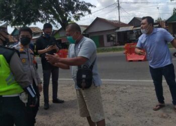 PEMANDU kenderaan memarahi pihak polis kerana mendakwa meminta RM30 sekiranya mahu melepasi sekatan jalan raya di simpang Nilakandi, Palembang. -KOMPAS.COM