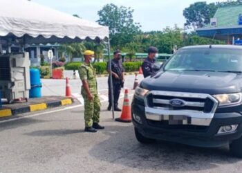 ANGGOTA polis memeriksa kenderaan di sekatan jalan raya (SJR) Plaza Tol Slim River di Slim River, Tanjung Malim, Perak hari ini. - IHSAN PDRM