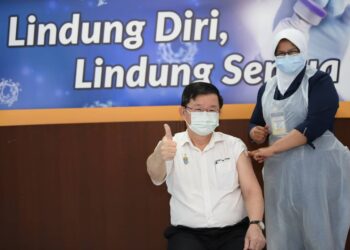 CHOW KON YEOW menunjukkan tanda isyarat bagus selepas selesai menerima suntikan vaksin Covid-19, Pfizer-BioNTech di Hospital Pulau Pinang (HPP).