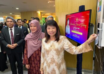 LIMHui Ying mengimbas kad perakam waktu sebagai simbolik memulakan tugas secara rasmi di KPM Putrajaya. - UTUSAN/KAMARIAH KHALIDI