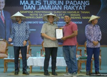 AHMAD Samsuri Mokhtar (dua dari kiri) menyampaikan Surat Hak Milik Tanah RTB DUN Rhu Rendang di Marang, Terengganu, hari ini. - UTUSAN/TENGKU DANISH BAHRI TENGKU YUSOFF