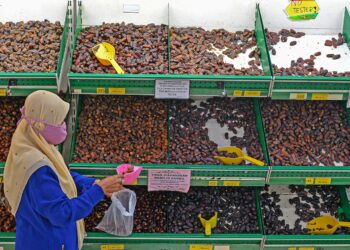 SEORANG pelanggan memilih kurma dijual di sebuah premis perniagaan yang menawarkan pelbagai jenis buah itu sempena Ramadan. – GAMBAR HIASAN.