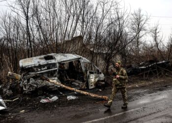 TENTERA Ukraine mengawal keselamatan di perkampungan Lukianivka, berdekatan Kyiv, selepas serangan menyebabkan kenderaan musnah terbakar.-AFP