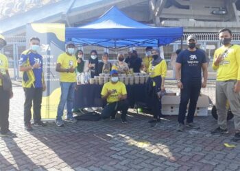 Kumpulan pemandu syarikat perkhidmatan penghantaran, Tapaw bersama bubur lambuk yang siap sedia untuk diagihkan kepada para pengunjung Bazar Ramadan Stadium Malawati, Shah Alam, semalam.