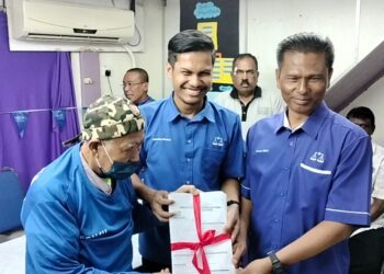 MOHD. SHAFIQ FHADLY MAHMUD (tengah) menerima penyerahan borang keahlian menyertai BN di Sungai Bayor, Larut semalam. - UTUSAN/WAT KAMAL ABAS