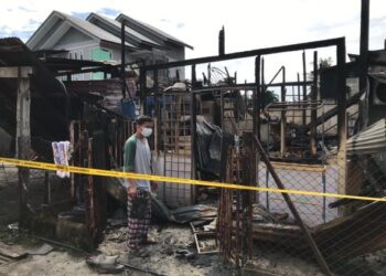 MOHD. Yusof Kamaruzaman melihat rumahnya yang rentung dalam kebakaran membabitkan sembilan kediaman di Lorong Nik Pa Jalan Sultanah Zainab, Kota Bharu, Kelantan, semalam. - UTUSAN/ROSLIZA MOHAMED