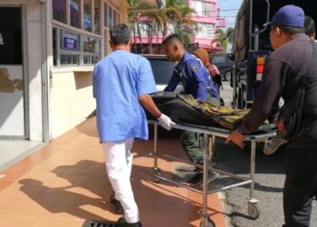 ANGGOTA polis mengusung mayat Muhammad Zuhaily Roslan di Unit Forensik Hospital Dungun, Terengganu, hari ini. - UTUSAN/NIK NUR IZZATUL HAZWANI NIK ADNAN