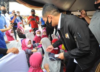 ONN Hafiz Ghazi menyampaikan duit raya kepada kanak-kanak asnaf sempena Majlis Pelancaran Jualan Semarak Syawal Peringkat Negeri Johor di Pasar Tani Datin Halimah di Johor Bahru di sini. UTUSAN/RAJA JAAFAR ALI