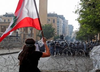 PENUNJUK perasaan mengibarkan bendera Lubnan ketika berdepan pasukan keselamatan di Beirut. Mereka melaungkan rasa marah terhadap kerajaan susulan letupan minggu lalu. - AFP