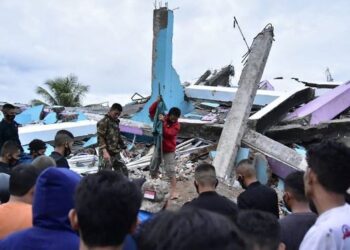 ORANG ramai melihat runtuhan bangunan yang diakibatkan oleh gempa bumi di bandar Mamuju, Sulawesi Barat. - AFP