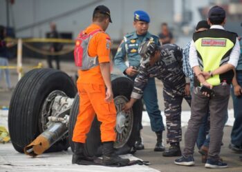 PASUKAN penyelamat meneliti bahagian tayar pesawat Lion Air yang terhempas di Tanjung Karawang pada Oktober 2018. - AFP