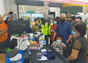 MAHFUZ Omar beramah mesra bersama keluarga pelajar yang menerima sumbangan kelengkapan persekolahan di sebuah pasar raya di Pokok Sena, Alor Setar, Kedah.