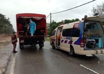 ANGGOTA BBP Jeli berpakaian PPE membawa keluar lelaki yang disahkan positif Covid-19 selepas terkandas akibat banjir di Kampung Reka, Jeli, Kelantan, hari ini. - FOTO/ROSALWANI CHE SOH