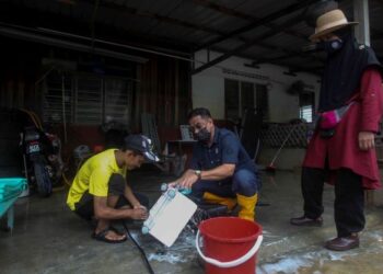 AZHAR Abdul Manaf (tengah) membantu membersihkan barangan penduduk dalam program Kampung Angkat KPLB di RTB Bukit Changgang di Kuala Langat, Selangor. - UTUSAN/FAISOL MUSTAFA