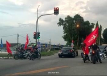 TANGKAP layar video tular memaparkan sekumpulan penunggang motosikal membawa bendera parti bertindak sebagai marsyal dengan menahan kenderaan lain di Taman Desa Dahlia, Senawang, Seremban.