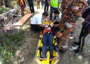 PETUGAS kesihatan memeriksa mangsa sejurus diselamatkan oleh rakannya setelah jatuh ke dalam sungai di Ladang Risda Bera di Bera, Pahang. - FOTO/IHSAN JBPM PAHANG
