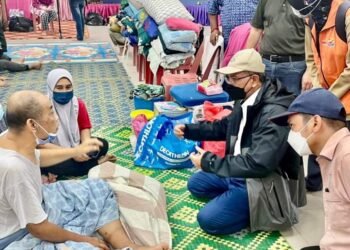 WAN ROSDY Wan Ismail (kanan, duduk tengah) berbual dengan seorang mangsa banjir ketika melawat PPS  di Bentong, Pahang.- FACEBOOK WAN ROSDY WAN ISMAIL